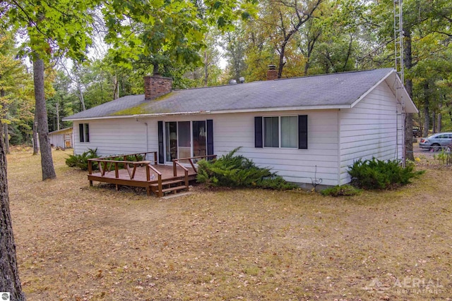 2169 Brady Dr, West Branch, MI 48661 - single story home featuring a chimney, a deck, roof with shingles, and view of scattered trees
