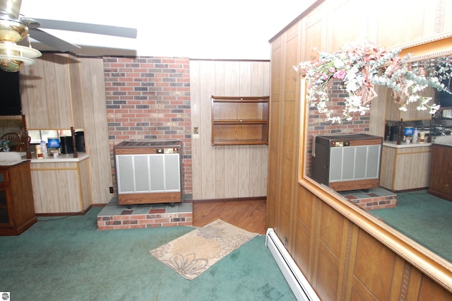 kitchen featuring light carpet, wooden walls, and ceiling fan