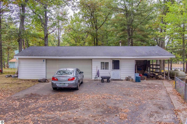 2169 Brady Dr, West Branch, MI 48661 - garage featuring driveway and view of scattered trees