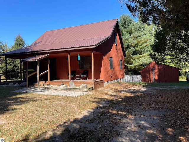 back of property featuring an outbuilding and a yard