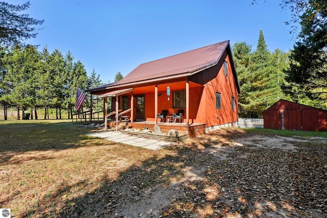 back of house with a patio, a yard, and an outbuilding