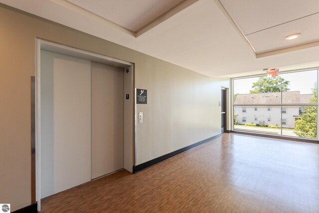 empty room with wood-type flooring and elevator