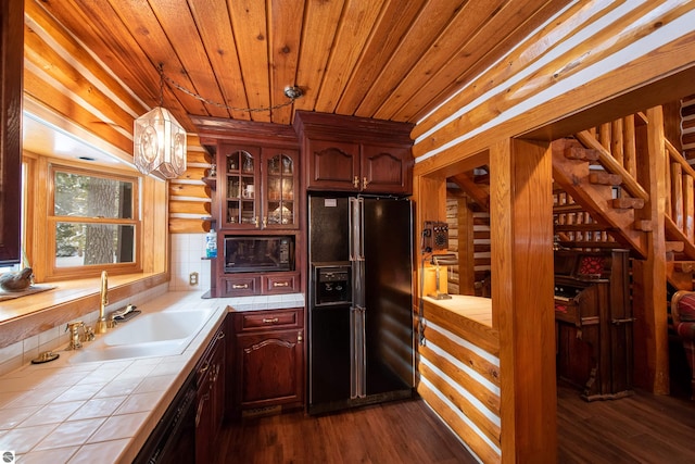 kitchen with black fridge, sink, dark hardwood / wood-style floors, tile counters, and wooden ceiling