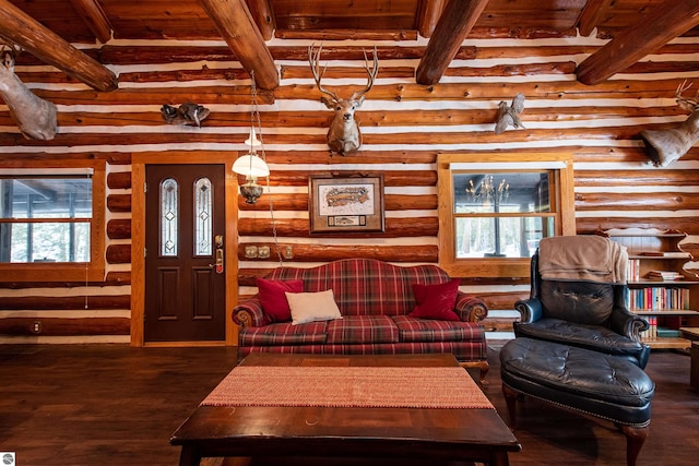 living room with beam ceiling, rustic walls, plenty of natural light, and dark hardwood / wood-style flooring