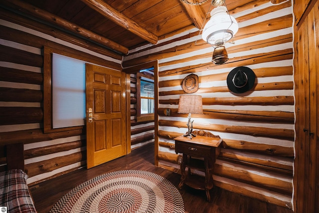 foyer with wooden ceiling, log walls, dark hardwood / wood-style flooring, and beamed ceiling