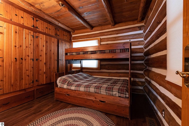 unfurnished bedroom with wooden walls, beam ceiling, wooden ceiling, and dark hardwood / wood-style flooring