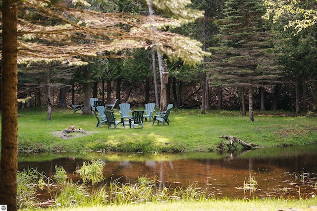 view of yard with a water view and an outdoor fire pit