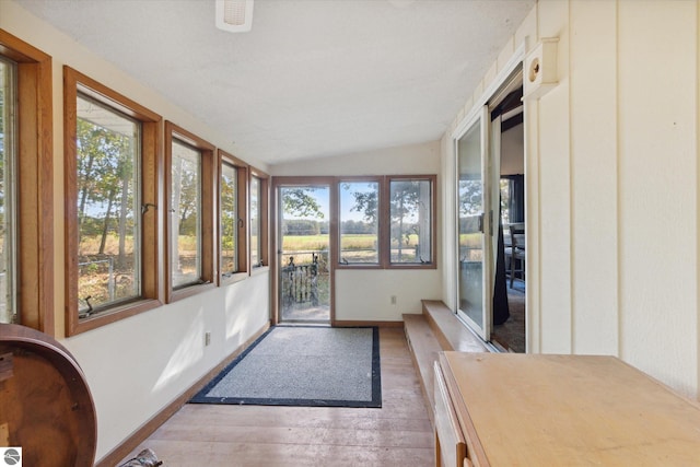 sunroom featuring vaulted ceiling and a wealth of natural light