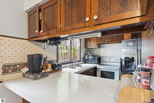 kitchen featuring white electric range, stainless steel fridge, and sink