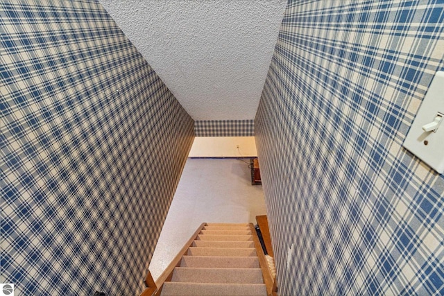 stairs with a textured ceiling