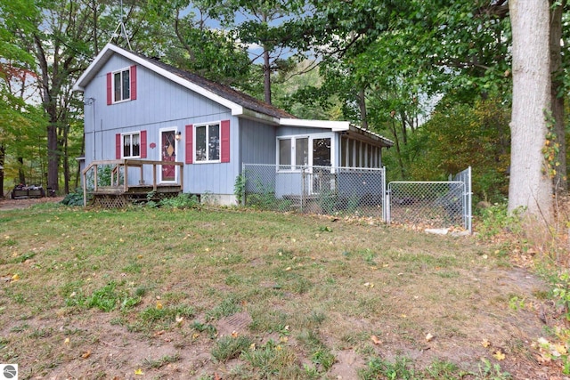 view of side of property featuring a lawn and a sunroom