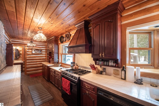 kitchen featuring rustic walls, dark wood-type flooring, black appliances, tile countertops, and custom range hood