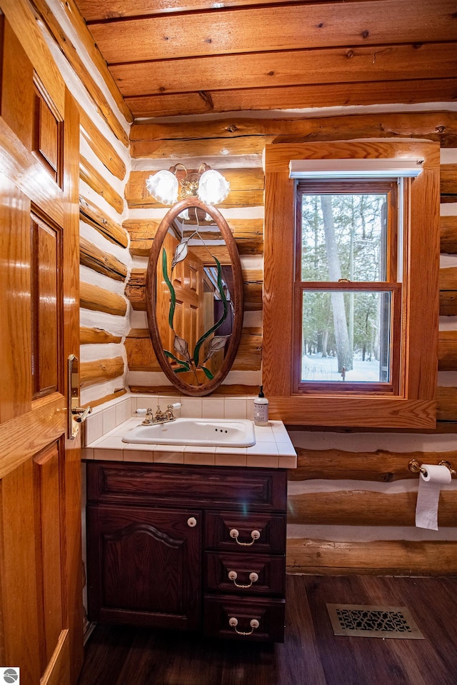 bathroom featuring wood ceiling, hardwood / wood-style floors, rustic walls, and vanity