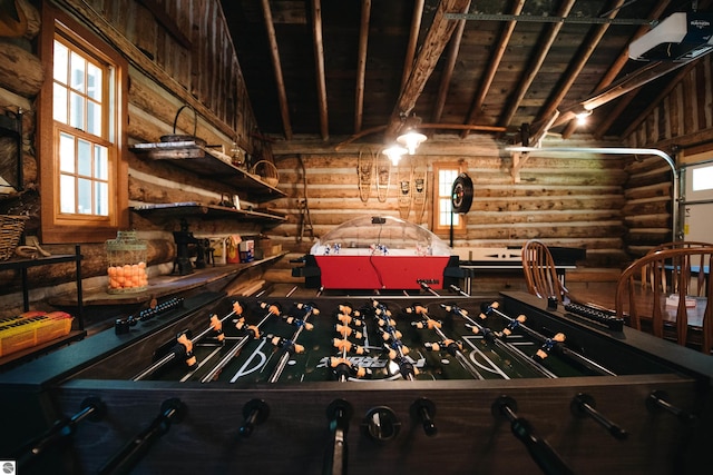 game room with vaulted ceiling with beams, log walls, and a wealth of natural light