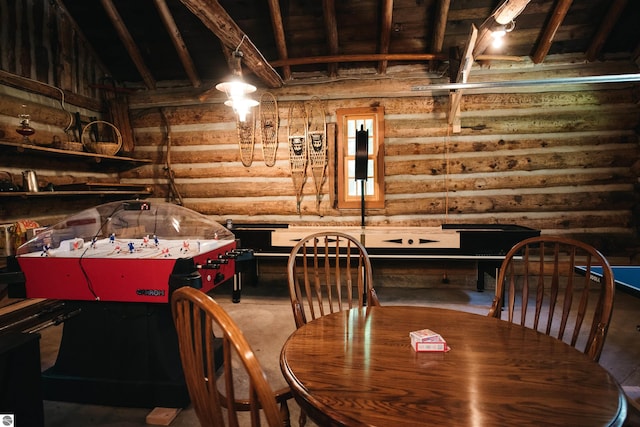 dining room with rustic walls and beam ceiling