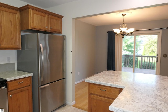 kitchen featuring stainless steel fridge, light hardwood / wood-style floors, a chandelier, and decorative light fixtures