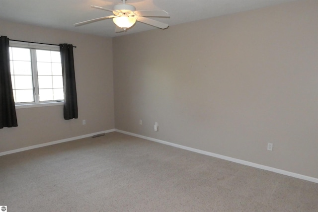 spare room featuring light carpet and ceiling fan