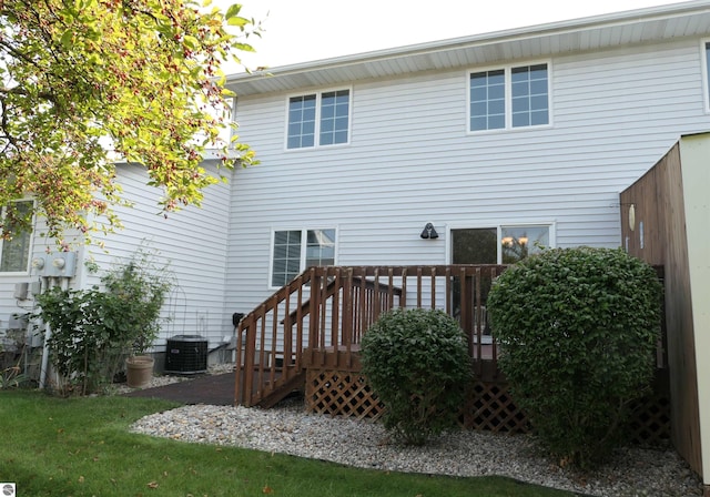 rear view of property featuring central AC and a wooden deck