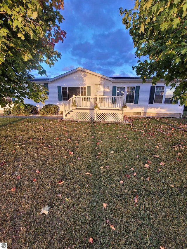 view of front of house featuring a lawn and a deck