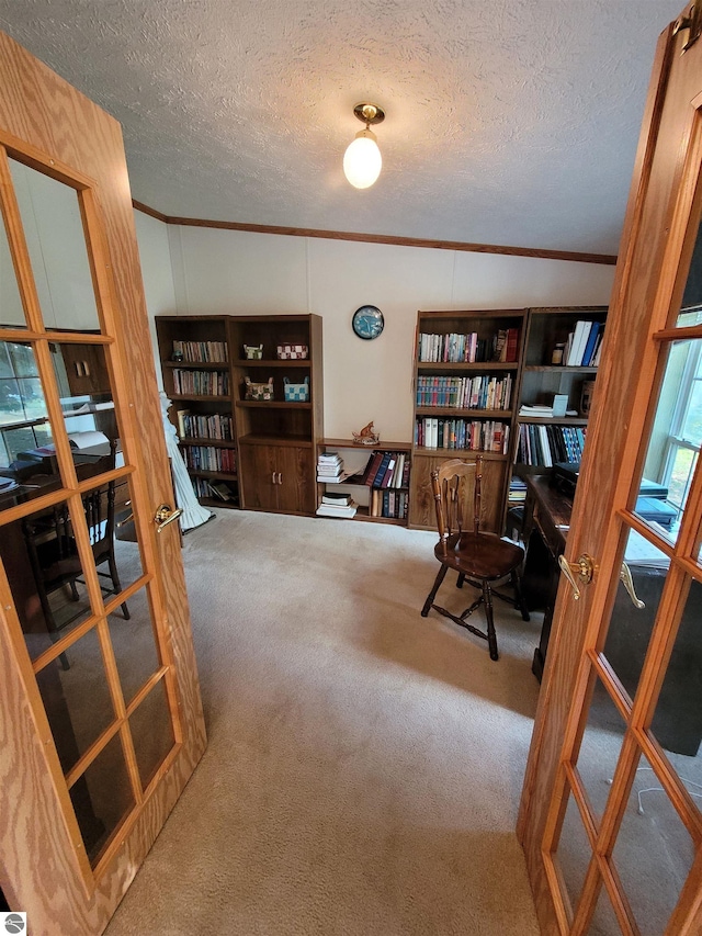 home office with carpet floors, a textured ceiling, crown molding, and french doors