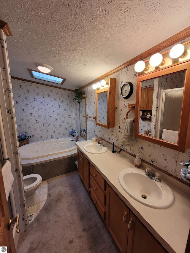 bathroom with a textured ceiling, a bathtub, a skylight, vanity, and toilet