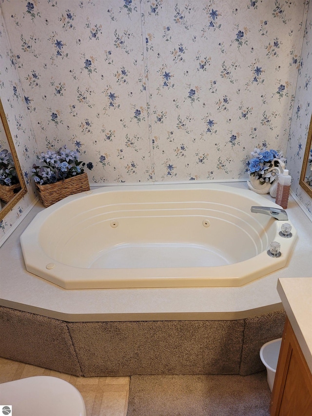 bathroom with vanity, toilet, and a bath