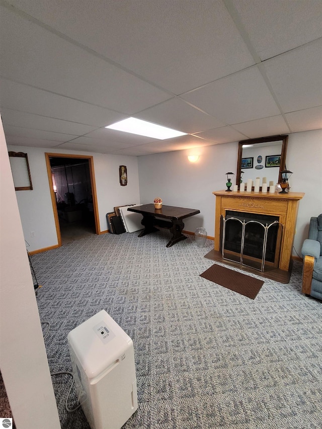 carpeted living room with a paneled ceiling