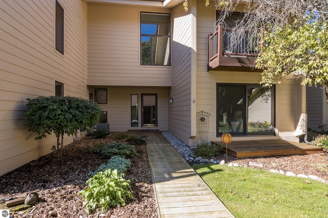 entrance to property with a balcony and a yard