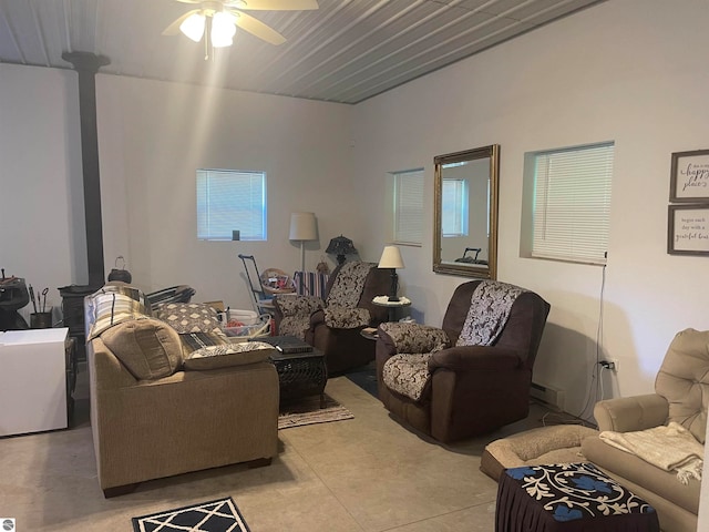 living room featuring ceiling fan and a wood stove