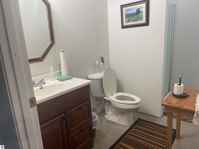 bathroom featuring vanity, tile patterned flooring, and toilet