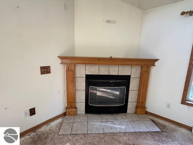 interior details featuring a tile fireplace