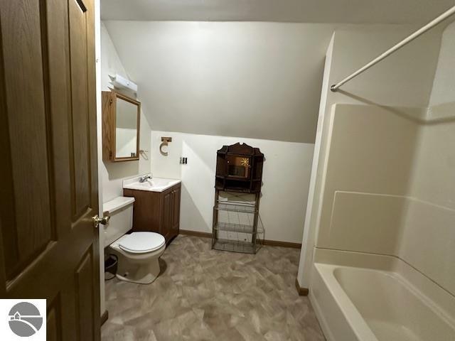 full bathroom featuring vanity, toilet, vaulted ceiling, and  shower combination