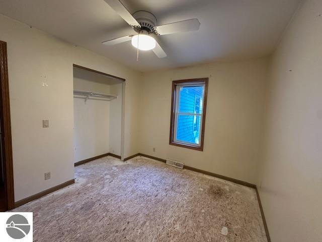 unfurnished bedroom featuring a closet, ceiling fan, and light colored carpet