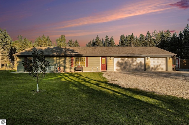 ranch-style house featuring a yard and a garage