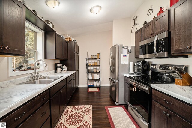 kitchen featuring dark brown cabinets, dark wood-type flooring, sink, lofted ceiling, and stainless steel appliances