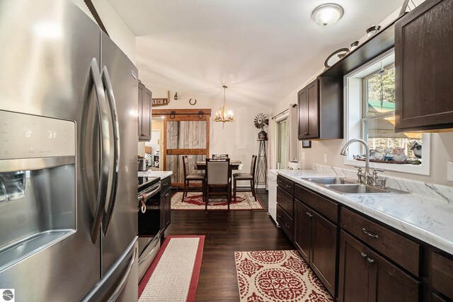 kitchen with sink, decorative light fixtures, dark wood-type flooring, appliances with stainless steel finishes, and vaulted ceiling