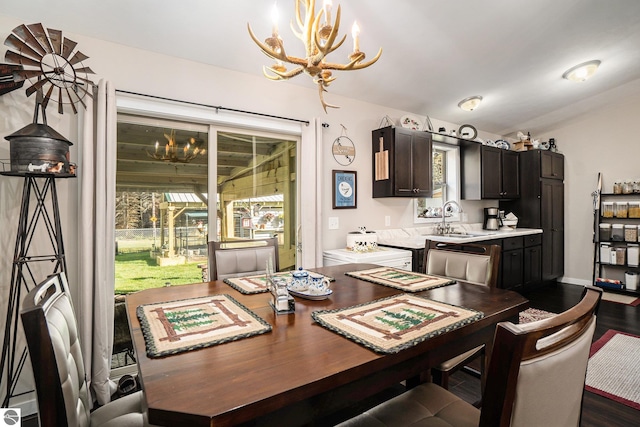 dining space with an inviting chandelier, sink, and dark wood-type flooring