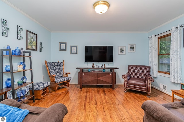 living room with ornamental molding and light wood-type flooring