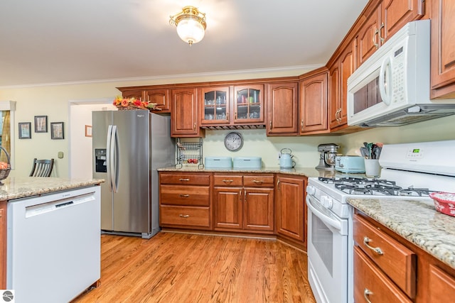 kitchen featuring light hardwood / wood-style floors, white appliances, ornamental molding, and light stone counters