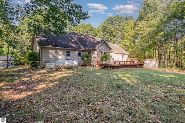 rear view of house featuring a wooden deck and a yard