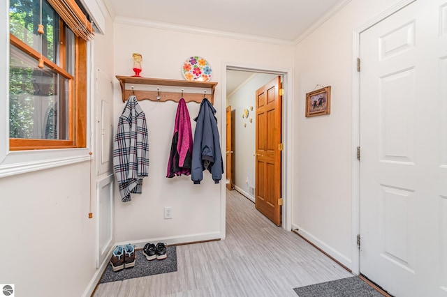 doorway featuring light wood-type flooring and crown molding