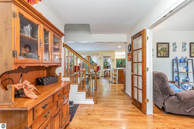 corridor featuring crown molding and light hardwood / wood-style floors