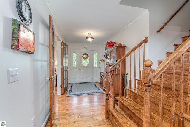 entrance foyer with light hardwood / wood-style floors and ornamental molding