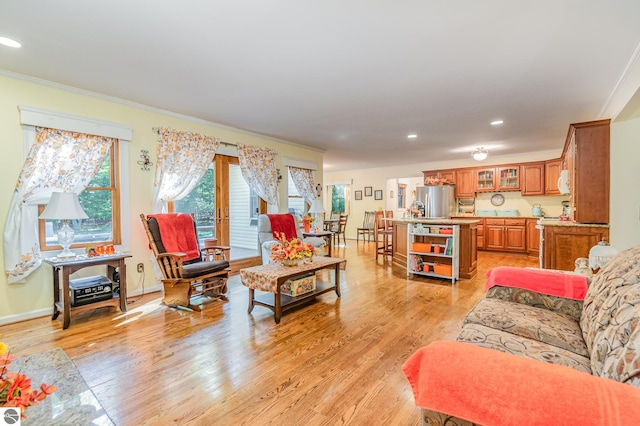 living room with ornamental molding and light hardwood / wood-style floors