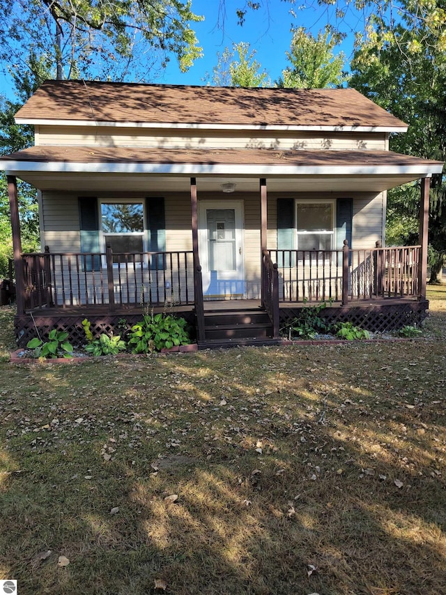 farmhouse-style home with a front yard and covered porch