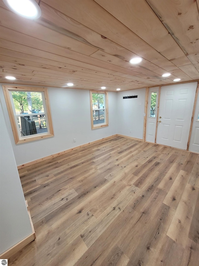 basement featuring light hardwood / wood-style flooring, a wealth of natural light, and wooden ceiling