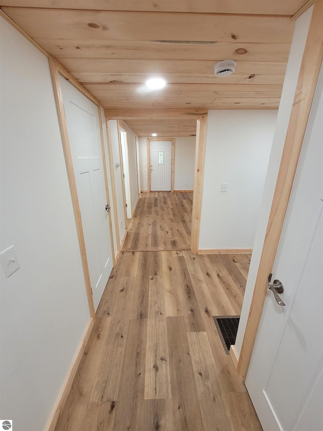 hallway featuring light hardwood / wood-style floors and wooden ceiling