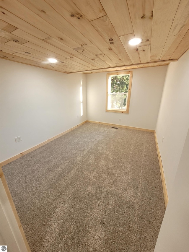 spare room featuring wood ceiling and carpet flooring