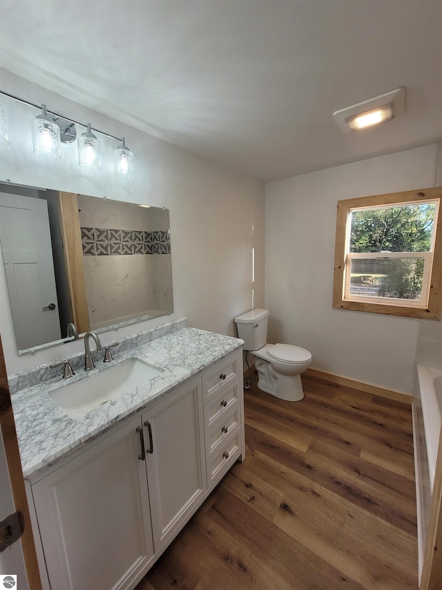 bathroom featuring vanity, a bathtub, toilet, and hardwood / wood-style flooring