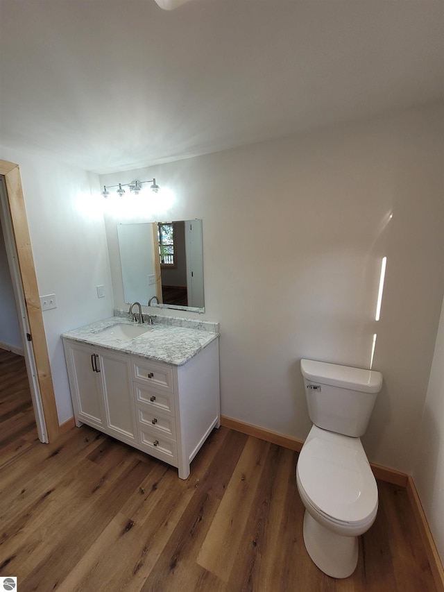 bathroom featuring hardwood / wood-style floors, vanity, and toilet